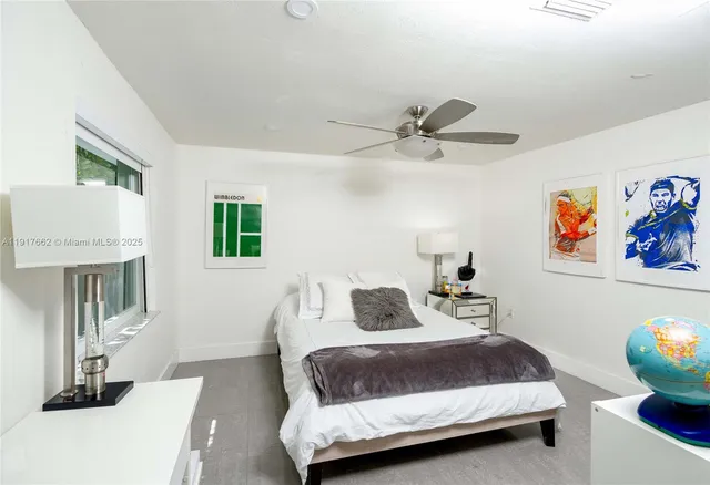 a bedroom with a bed a couch and a painting on the wall