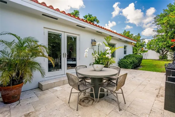 a view of a patio with table and chairs potted plants with wooden fence