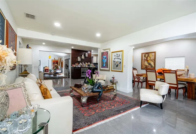 a living room with furniture and a dining table with wooden floor