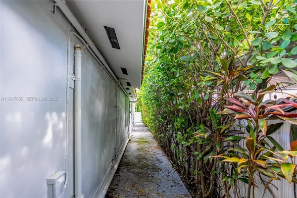 a view of a pathway of a house with wooden fence
