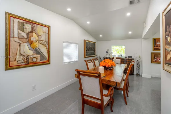 a dining room with furniture and a potted plant