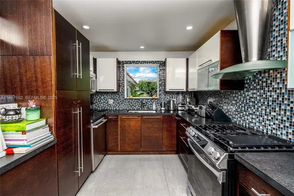 a kitchen with stainless steel appliances granite countertop a stove a sink and a microwave