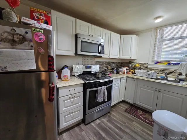 a kitchen with stainless steel appliances granite countertop a sink stove and cabinets