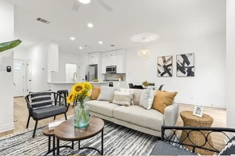 a living room with furniture and kitchen view