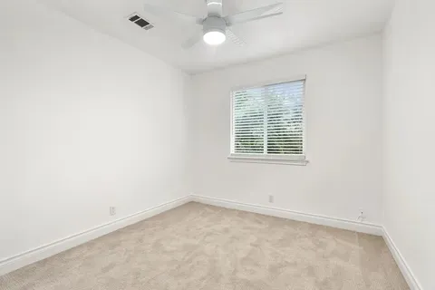 a view of backyard with potted plants and wooden fence