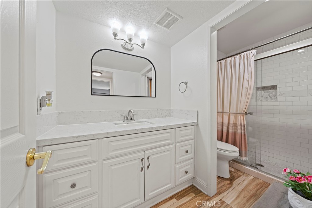 24243 Lema Drive Valencia, CA 91355 - Photo 15 of 37 a bathroom with a sink a toilet a mirror and shower