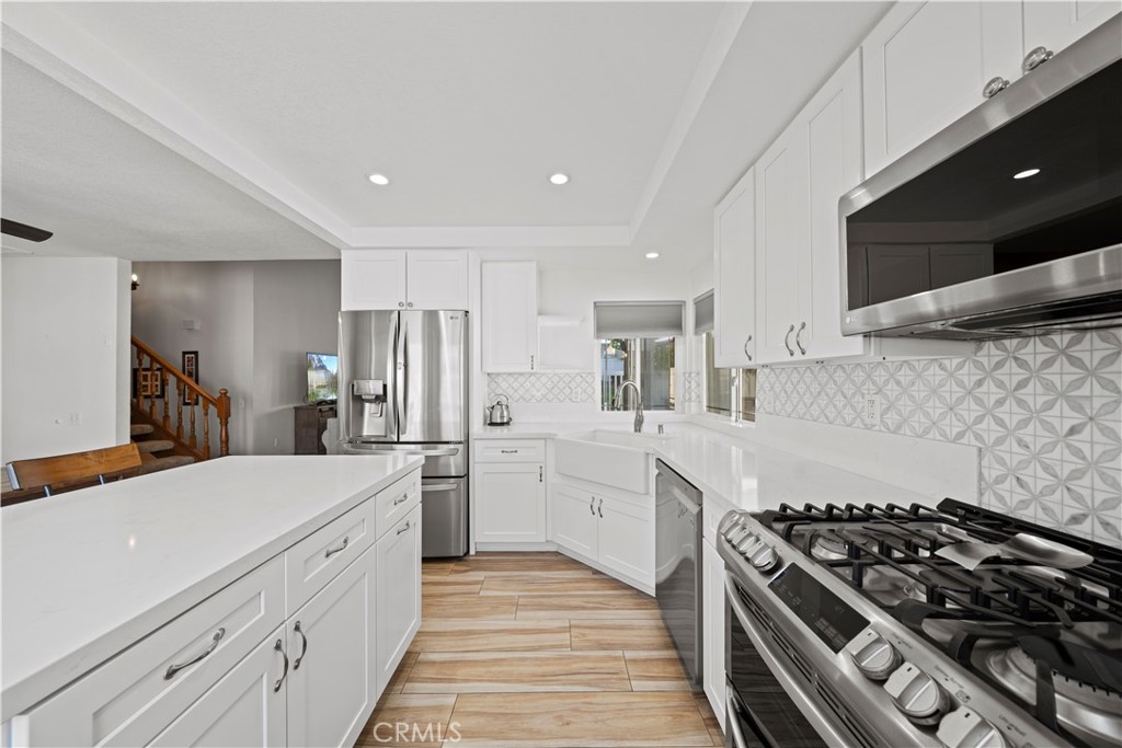 24243 Lema Drive Valencia, CA 91355 - Photo 4 of 37 a kitchen with white cabinets and appliances