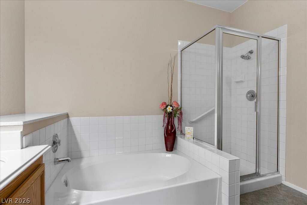 2201 Ramsgate Drive, Unit 818 Henderson, NV 89074 - Photo 14 of 31 Full bath with vanity, a shower stall, and a garden tub