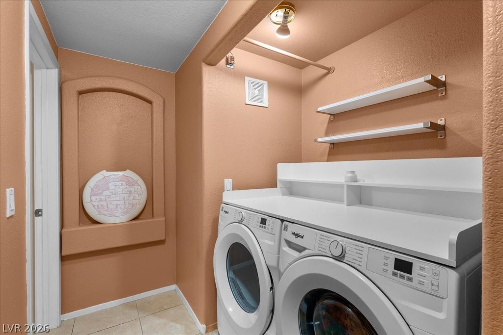 2201 Ramsgate Drive, Unit 818 Henderson, NV 89074 - Photo 20 of 31 Laundry room with a textured wall, washer and clothes dryer, and light tile patterned flooring