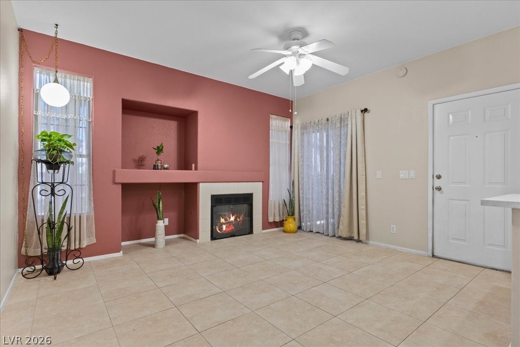 2201 Ramsgate Drive, Unit 818 Henderson, NV 89074 - Photo 2 of 31 Unfurnished living room featuring a fireplace, ceiling fan, and light tile patterned floors