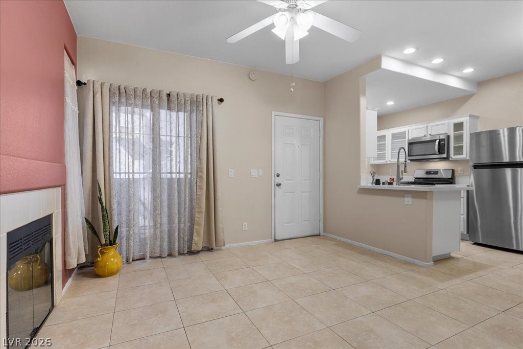 2201 Ramsgate Drive, Unit 818 Henderson, NV 89074 - Photo 21 of 31 Kitchen with stainless steel appliances, a peninsula, ceiling fan, glass insert cabinets, and light countertops