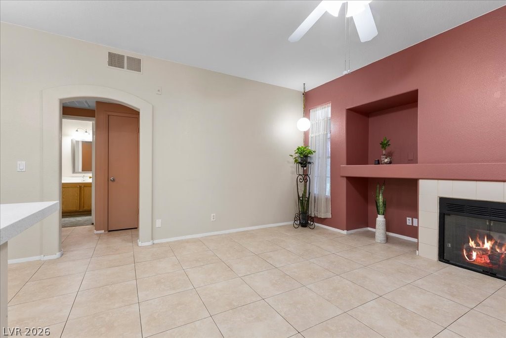 2201 Ramsgate Drive, Unit 818 Henderson, NV 89074 - Photo 3 of 31 Unfurnished living room with a fireplace, arched walkways, ceiling fan, and light tile patterned flooring