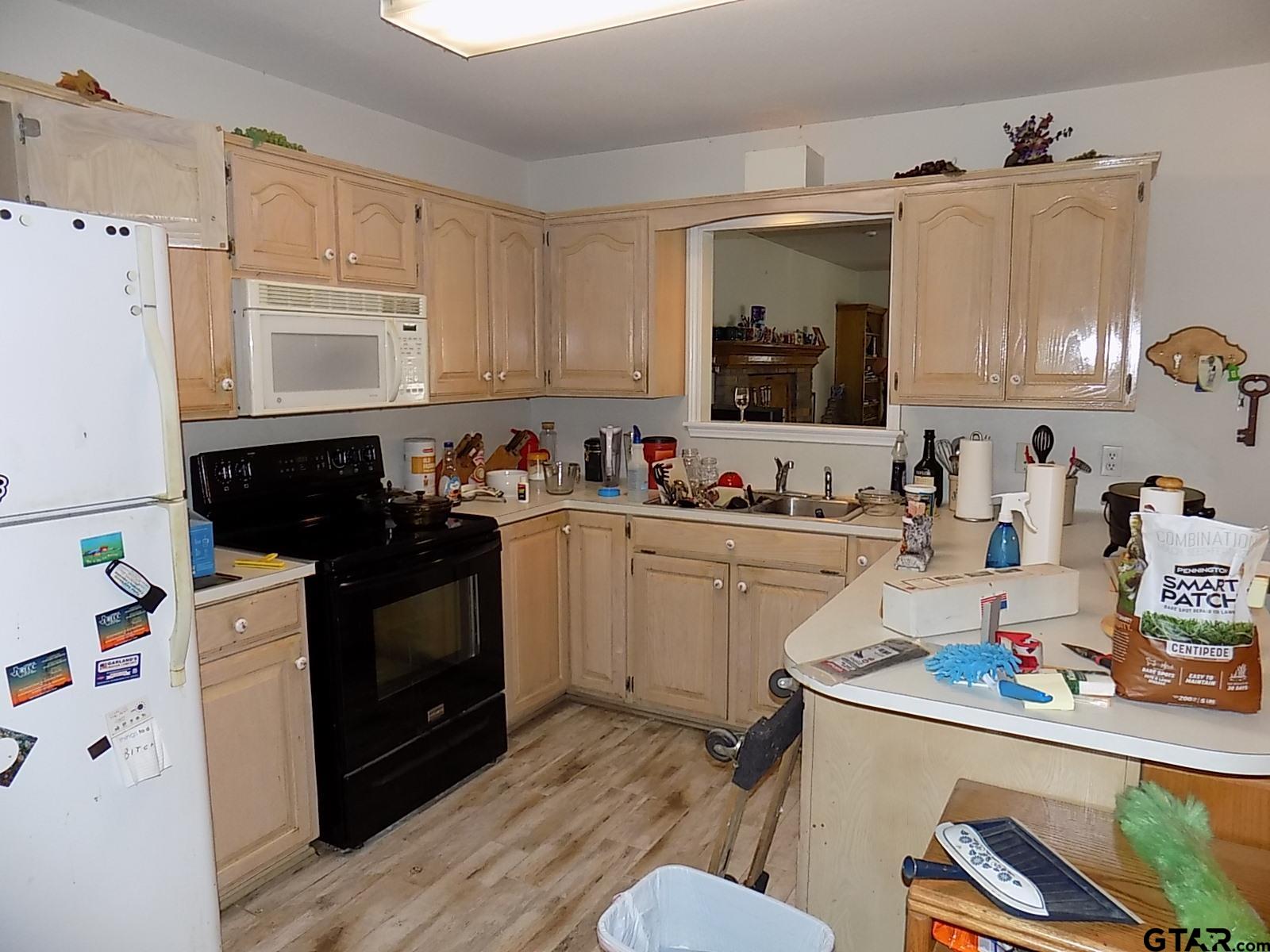 111 Laurel Lane Holly Lake Ranch, TX 75765 - Photo 23 of 43 a kitchen with a sink stove and white cabinets
