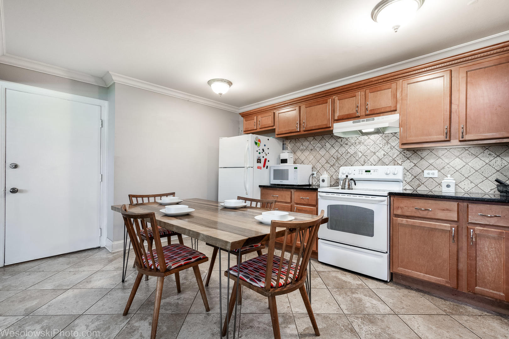 1288 Perry Street, Unit P1 Des Plaines, IL 60016 - Photo 5 of 13 a kitchen with stainless steel appliances kitchen island granite countertop a table chairs sink and cabinets
