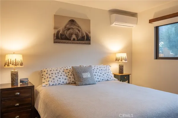 a bedroom with a bed and painting on the wall