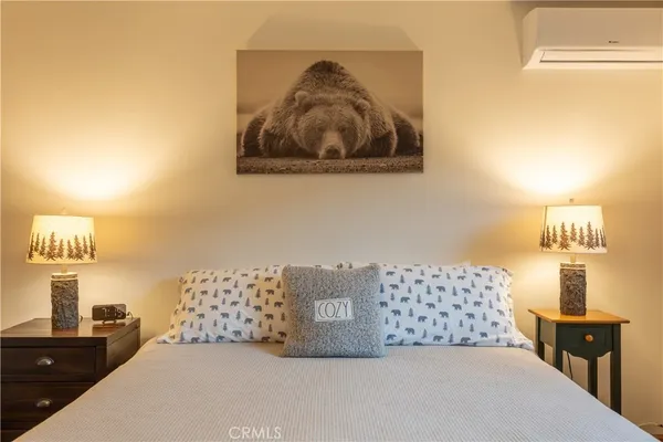 a bedroom with a bed and a lamp on dresser