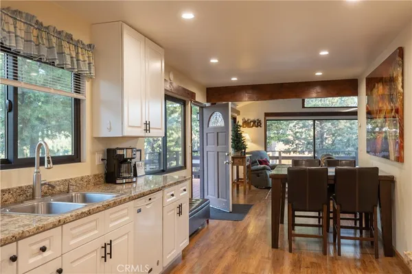 a kitchen with stainless steel appliances granite countertop sink stove refrigerator dining table and chairs