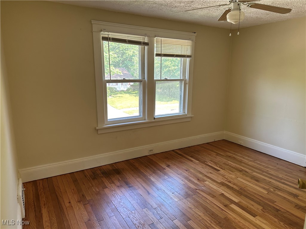 1596 Wood Road Cleveland Heights, OH 44121 - Photo 13 of 25 Empty room with a ceiling fan, hardwood / wood-style flooring, and a textured ceiling