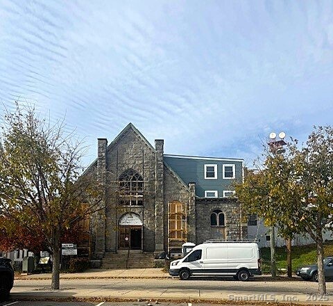 a front view of a building with lot of cars