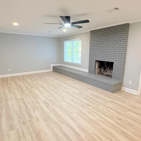 an empty room with windows and fireplace