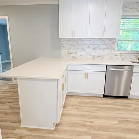 a kitchen with granite countertop white cabinets and a sink