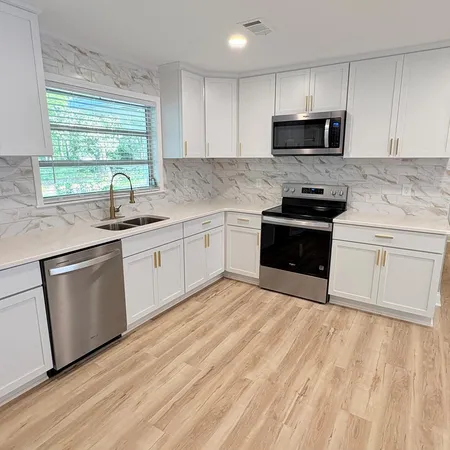 a kitchen with sink a microwave and cabinets