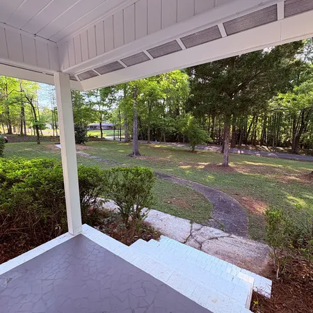 a view of a backyard with porch and garden