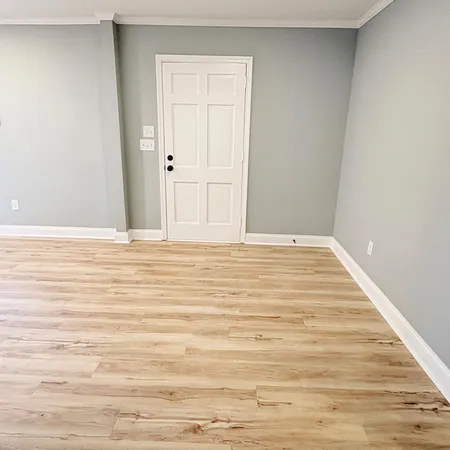 a view of a room with wooden floor