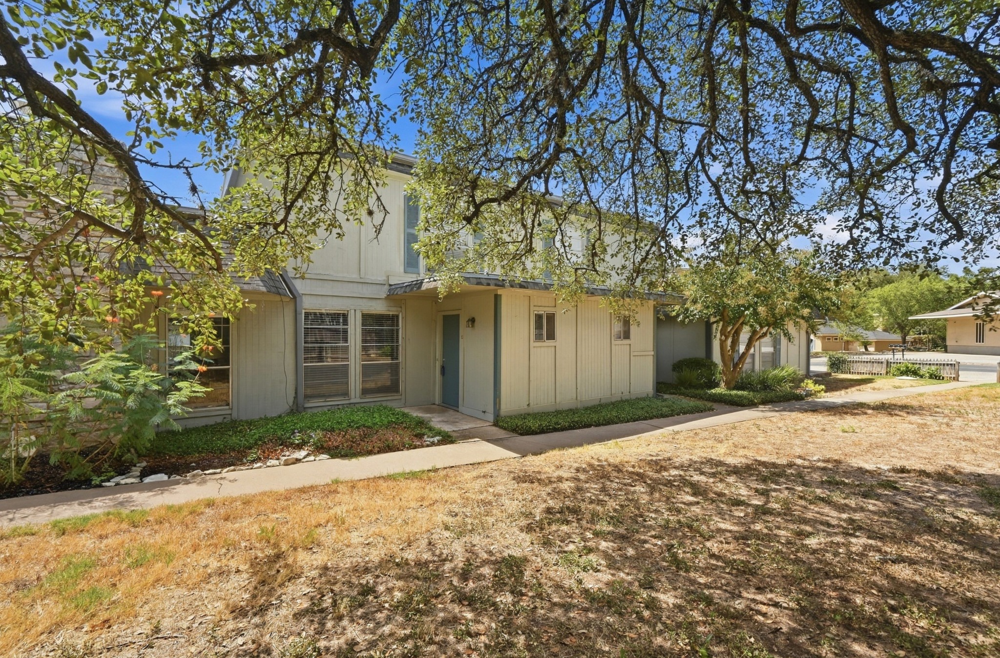 Mature shade trees frame the welcoming entrance path of this classic multi-level residence.
