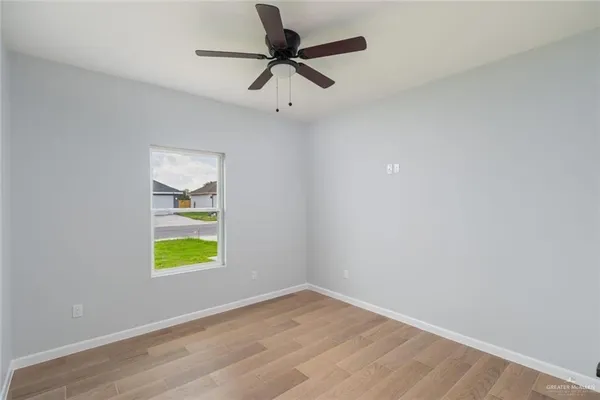 an empty room with a window and ceiling fan
