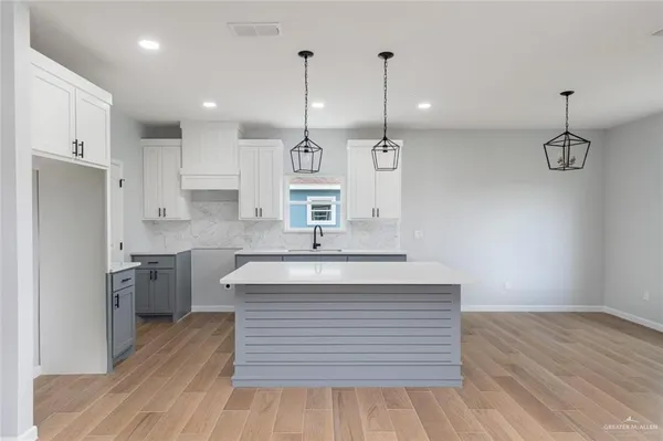 a kitchen with kitchen island a sink stainless steel appliances and cabinets