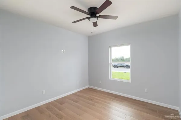 an empty room with a window and a fan