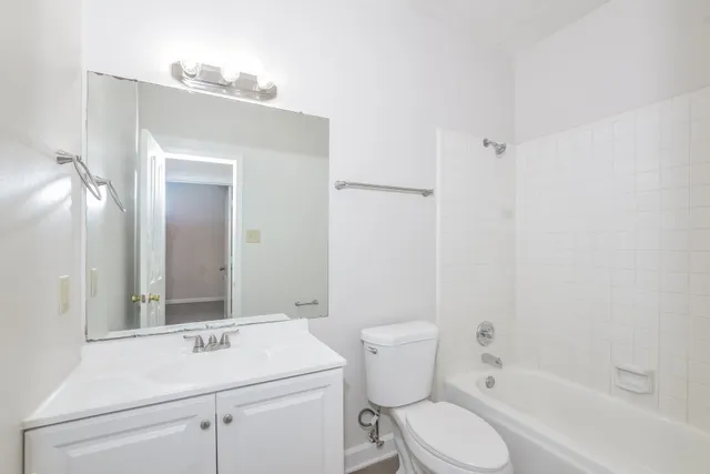 a bathroom with a sink toilet vanity and shower