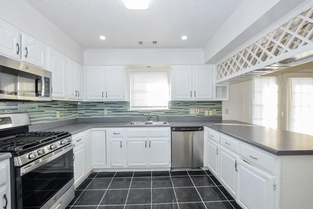 a kitchen with a stove sink and cabinets