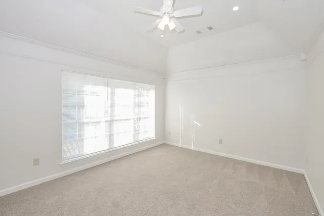 an empty room with a window and ceiling fan