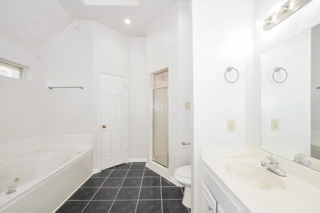 a bathroom with a bathtub sink vanity and a shower
