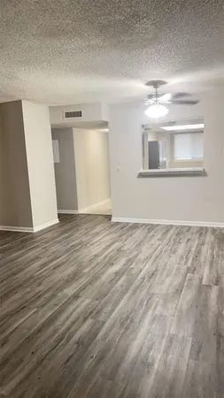 a view of empty room with wooden floor
