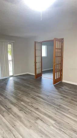 an empty room with wooden floor and windows