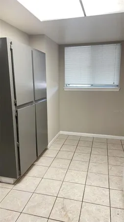 a view of a refrigerator in kitchen and white cabinets