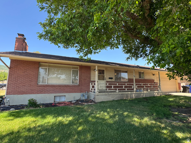 1611 South 75 East Bountiful, UT 84010 - Photo 1 of 6 Exterior featuring red brick and light-colored siding, a covered porch with brick accents, and an integrated garage