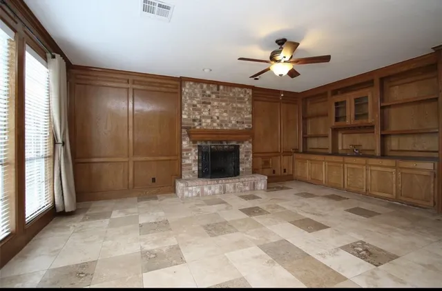 a view of an empty room with a ceiling fan and window