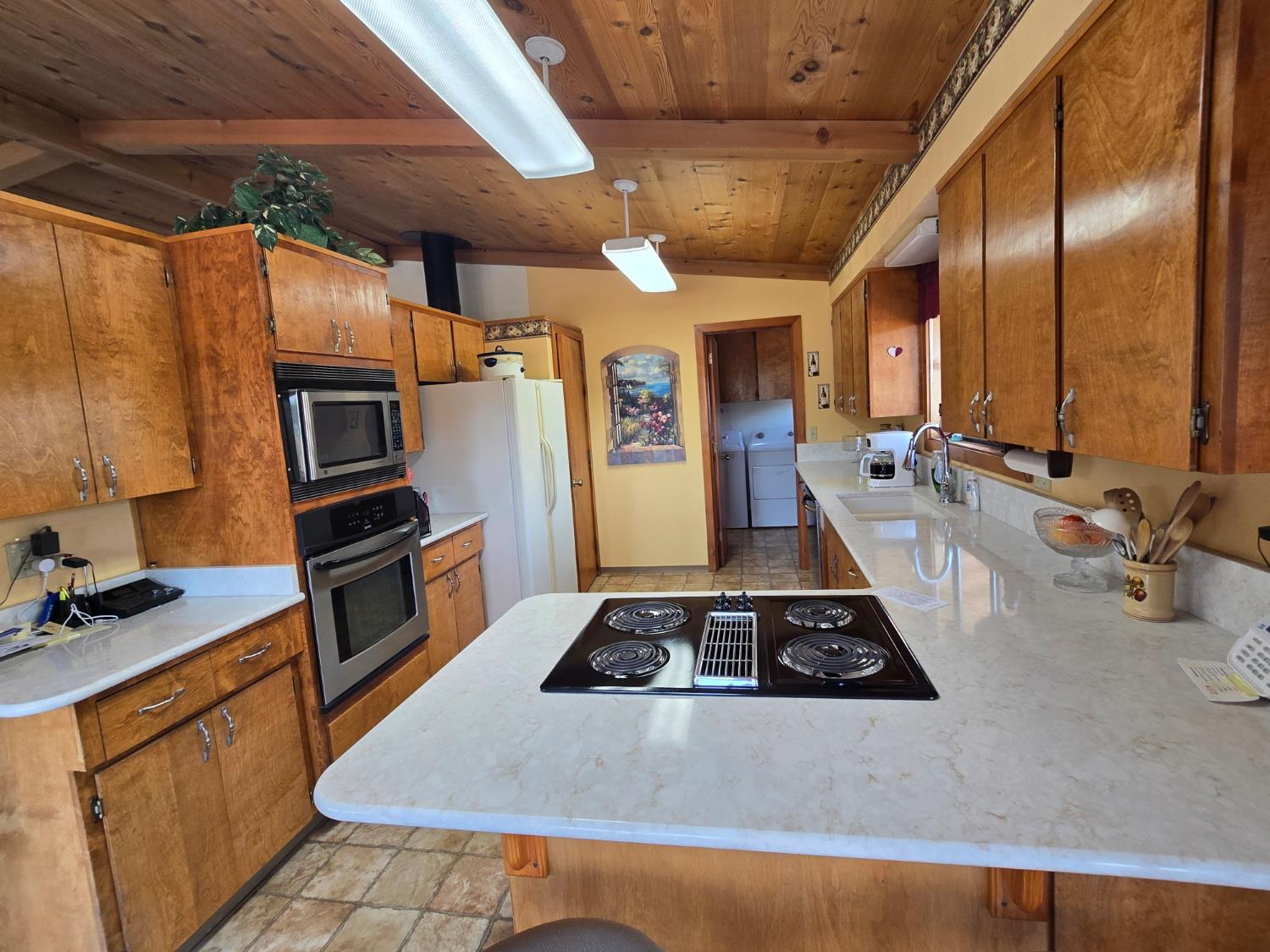 4204 Highway 263 Yreka, CA 96097 - Photo 14 of 66 a kitchen with stainless steel appliances a stove a sink a refrigerator wooden floor and cabinets