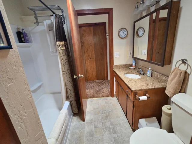 a bathroom with a granite countertop sink toilet and shower