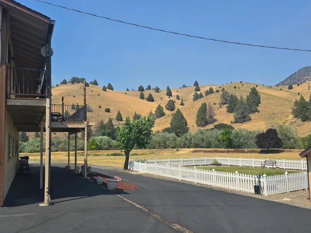 a kitchen with stainless steel appliances a stove a sink a refrigerator wooden floor and cabinets