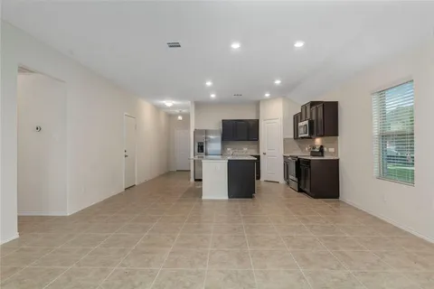 an empty room with windows and fireplace