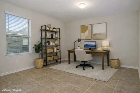 a view of a workspace with furniture and a window