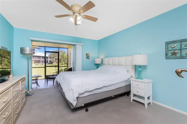 a spacious bedroom with a bed and a flat tv screen on dresser