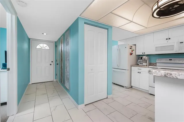 a view of a kitchen with refrigerator and cabinets