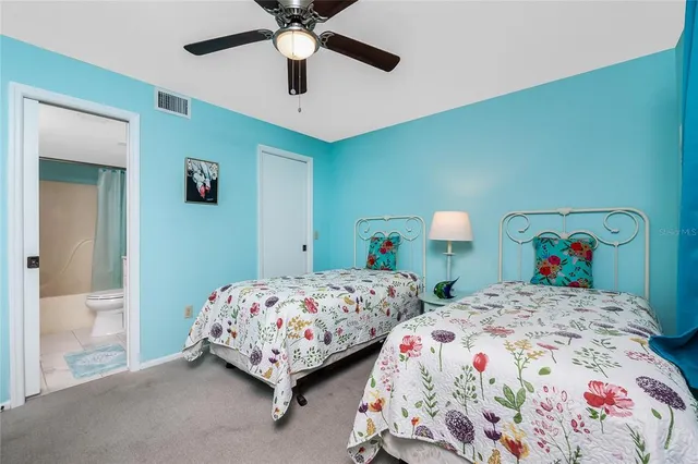 a bedroom with two beds and a painting on the wall