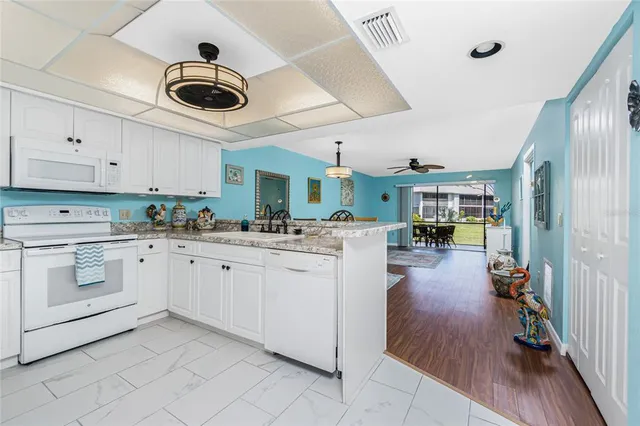 a kitchen with a stove cabinets and chairs